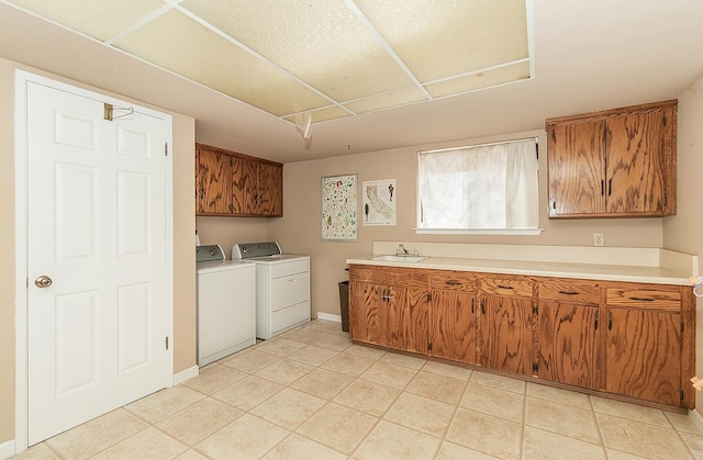 laundry room featuring cabinets, washer and dryer, sink, and light tile patterned floors