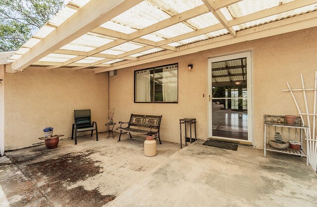 property entrance with a patio area and a pergola