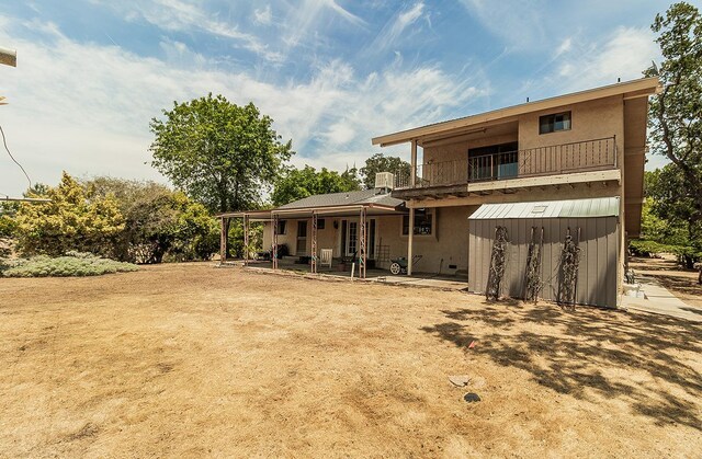 back of property with a balcony and a patio