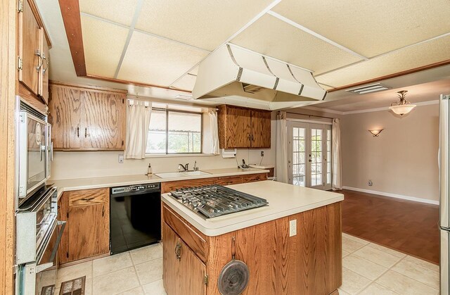 kitchen with a kitchen island, a healthy amount of sunlight, light wood-type flooring, and black dishwasher