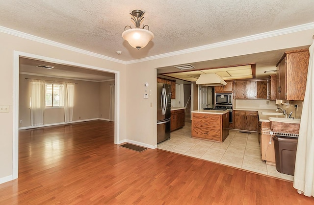 kitchen with pendant lighting, stainless steel fridge, ornamental molding, light hardwood / wood-style floors, and built in microwave