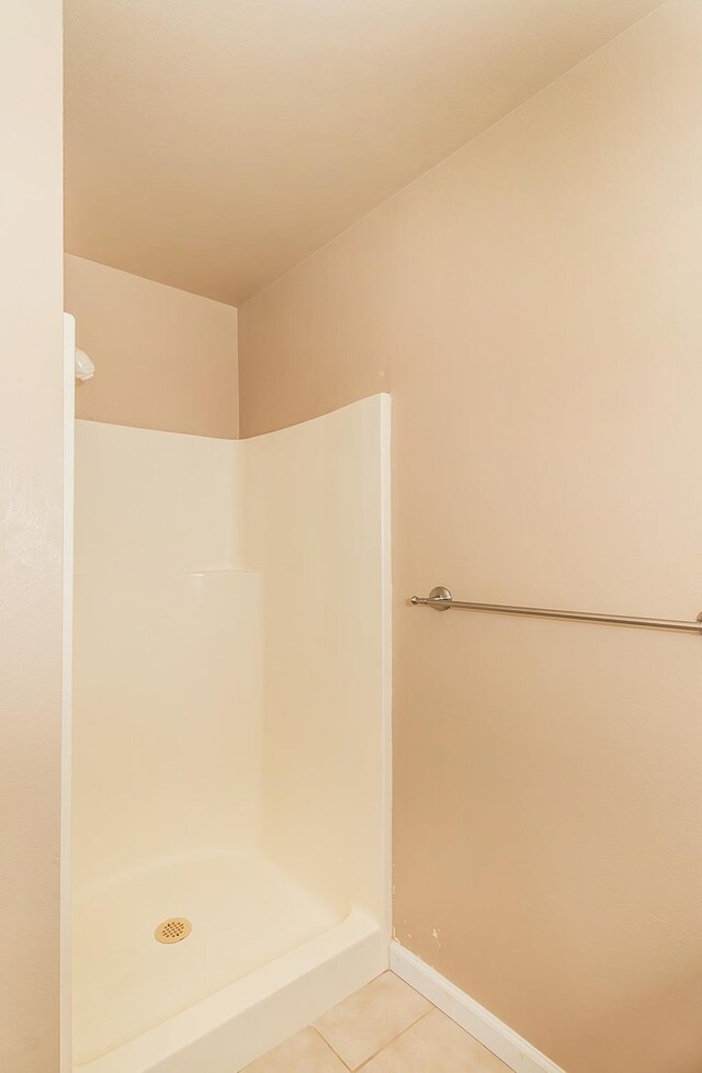 bathroom with tile patterned floors and a shower