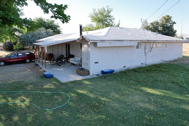 view of property exterior with a patio and a lawn