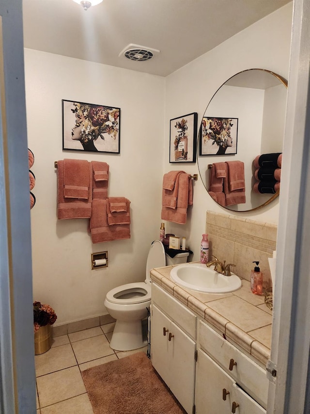 bathroom with tasteful backsplash, tile patterned floors, toilet, and vanity