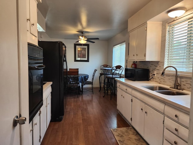 kitchen with sink, dark hardwood / wood-style floors, black appliances, white cabinets, and decorative backsplash