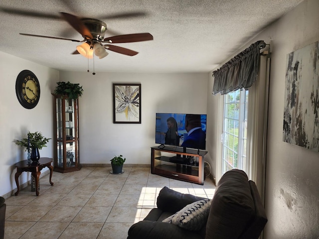 living room featuring light tile patterned floors, a textured ceiling, and ceiling fan