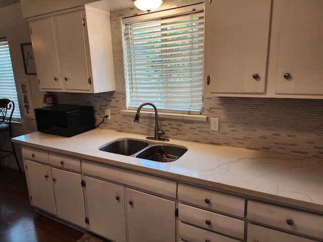 kitchen featuring sink, white cabinets, dark hardwood / wood-style floors, and decorative backsplash