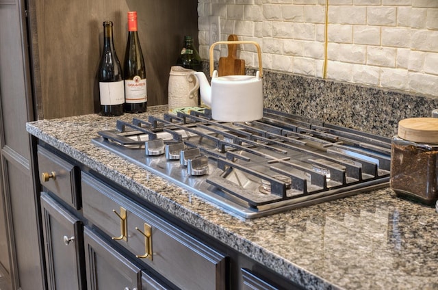 interior details featuring backsplash and stainless steel gas stovetop