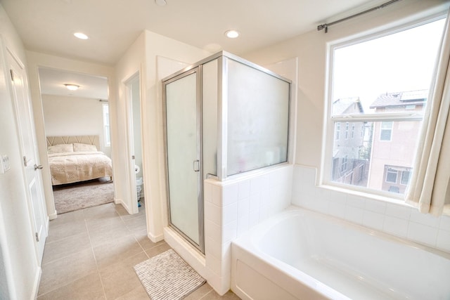 bathroom with tile floors, a wealth of natural light, and independent shower and bath