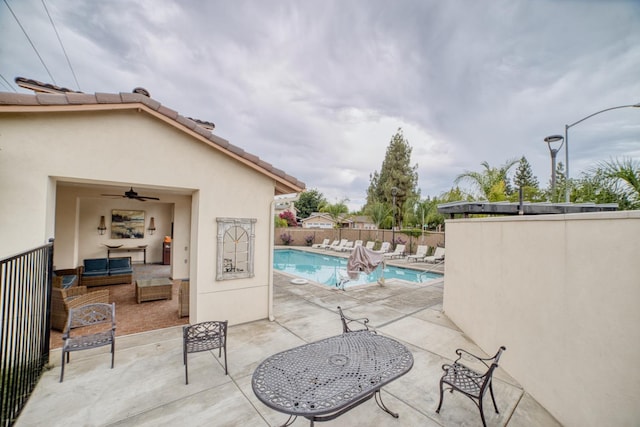 view of swimming pool featuring a patio, an outdoor living space, and ceiling fan