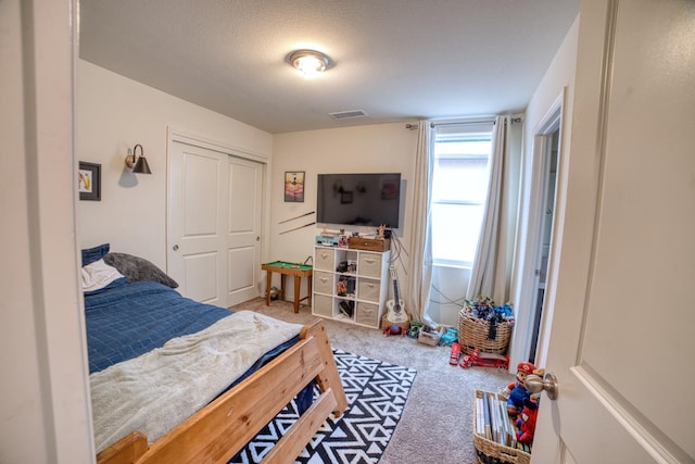 bedroom featuring a closet, a textured ceiling, and carpet floors