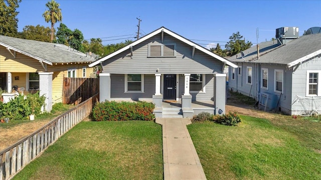 bungalow with covered porch and a front yard