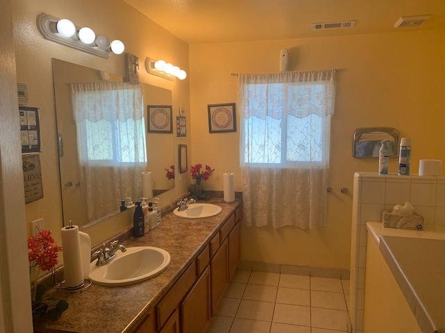 bathroom featuring a bathtub, tile flooring, and dual vanity