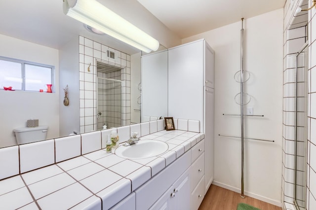 bathroom featuring hardwood / wood-style flooring, vanity, and toilet