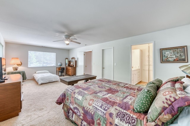 carpeted bedroom with ceiling fan and ensuite bath