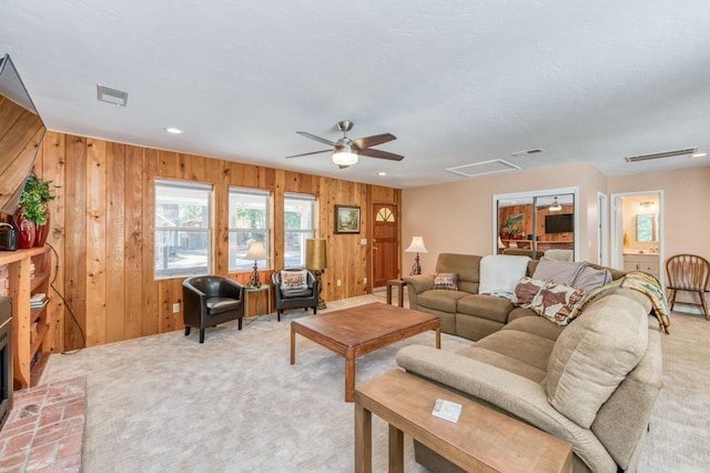 living room featuring carpet, ceiling fan, and wood walls