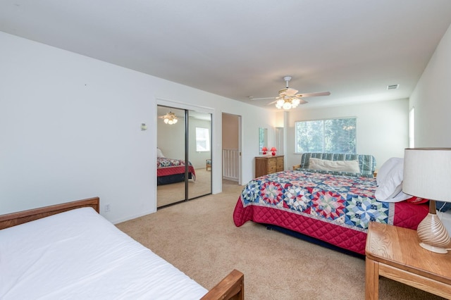 bedroom featuring light colored carpet, a closet, and ceiling fan