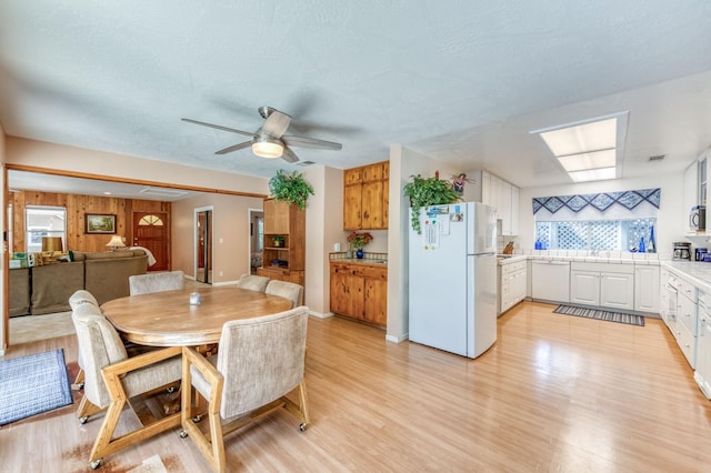 dining space featuring ceiling fan and light wood-type flooring