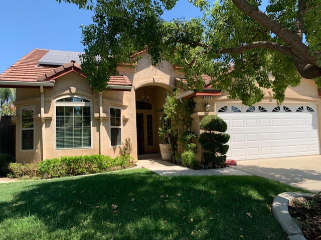 mediterranean / spanish house with a garage and a front yard