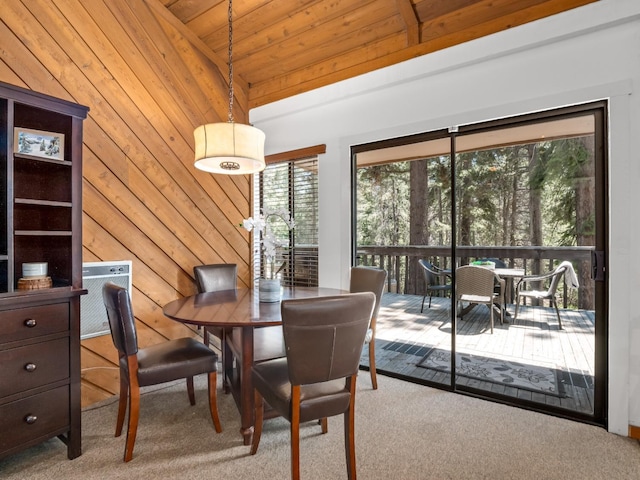 carpeted dining area featuring wood walls, wood ceiling, and vaulted ceiling