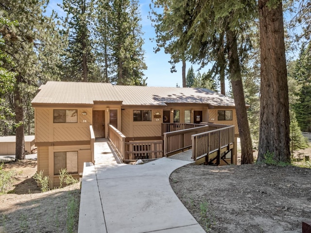 view of front of home with metal roof and a wooden deck