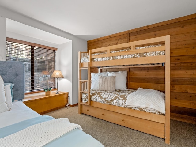 carpeted bedroom featuring wooden walls