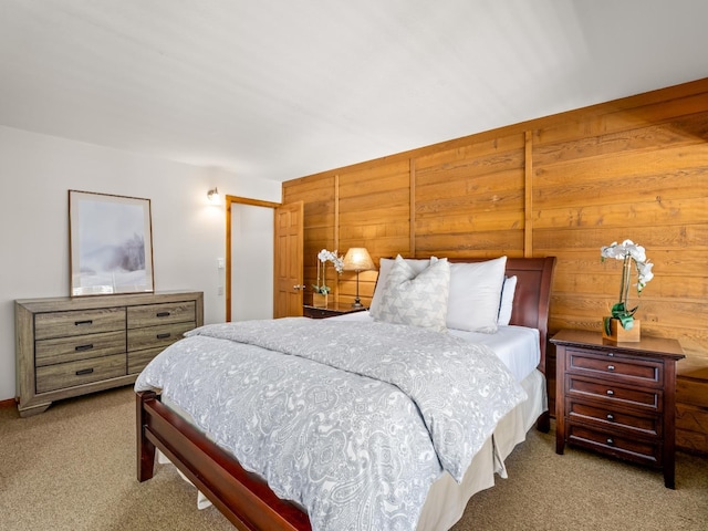 carpeted bedroom featuring wooden walls