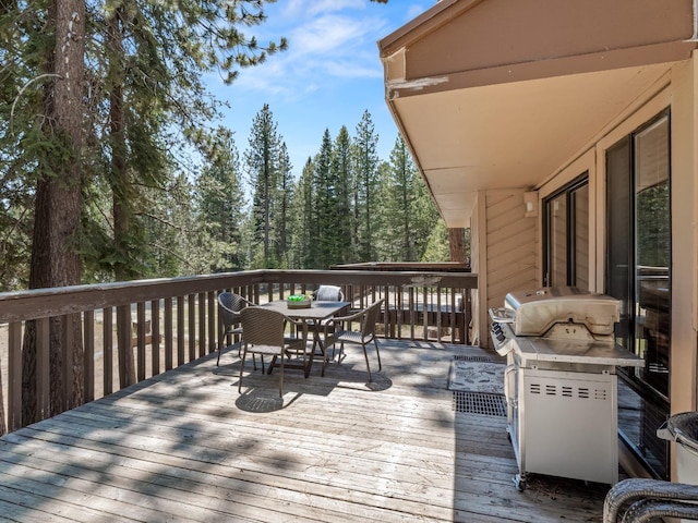 wooden deck with grilling area and outdoor dining area