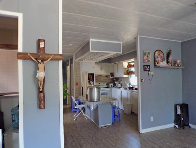 kitchen featuring dark wood-type flooring, kitchen peninsula, white cabinets, and white range with electric stovetop