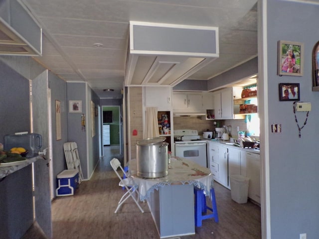36839 Hopewell Rd, Yokuts Valley, CA 93675 - kitchen with white electric stove, dark wood-style flooring, white cabinets, and a breakfast bar area