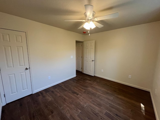 unfurnished bedroom featuring dark hardwood / wood-style flooring and ceiling fan