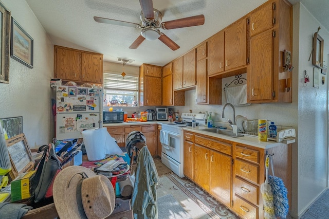 kitchen featuring sink, white appliances, light tile patterned floors, ceiling fan, and a textured ceiling