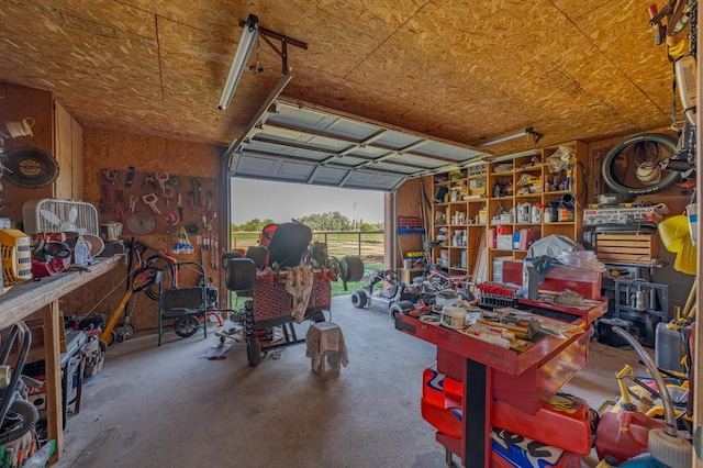 garage featuring wooden walls and a workshop area