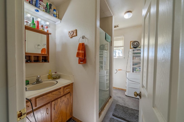 bathroom with vanity and a shower with shower door