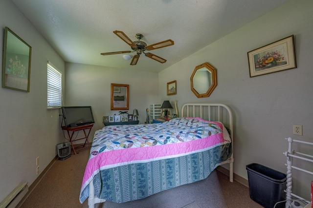 carpeted bedroom featuring ceiling fan, a textured ceiling, and a baseboard heating unit