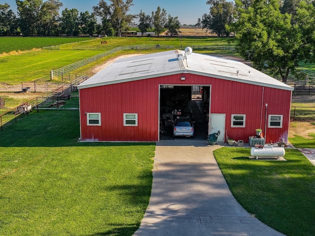 view of outbuilding featuring a rural view and a yard