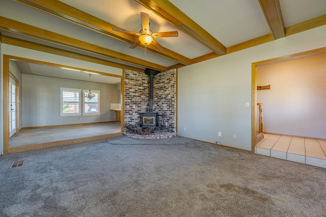 unfurnished living room featuring beamed ceiling, a wood stove, light carpet, and ceiling fan