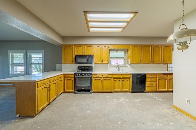 kitchen with decorative light fixtures, kitchen peninsula, sink, and black appliances