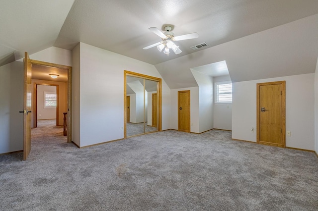 bonus room with plenty of natural light, light colored carpet, and vaulted ceiling