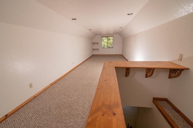 bonus room with lofted ceiling and carpet