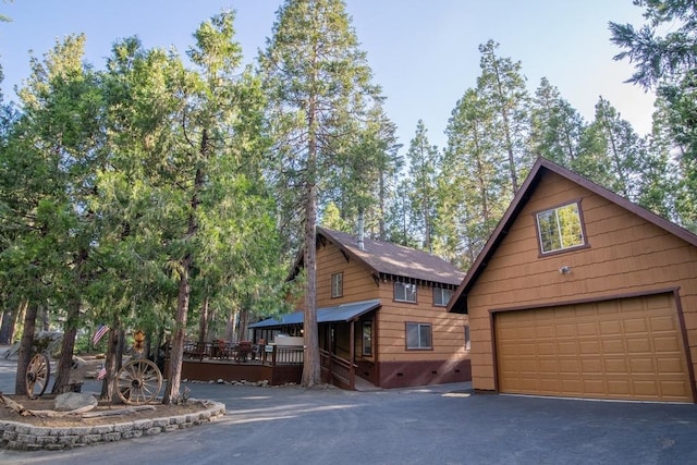 log cabin featuring a garage and an outdoor structure