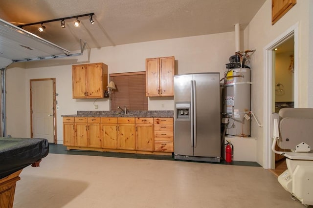 kitchen featuring sink, light brown cabinets, stainless steel fridge, and secured water heater