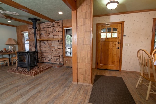 foyer featuring a healthy amount of sunlight, hardwood / wood-style floors, and a wood stove