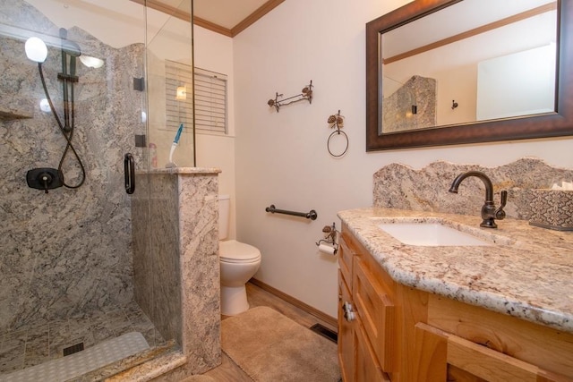 bathroom featuring crown molding, vanity, toilet, and walk in shower