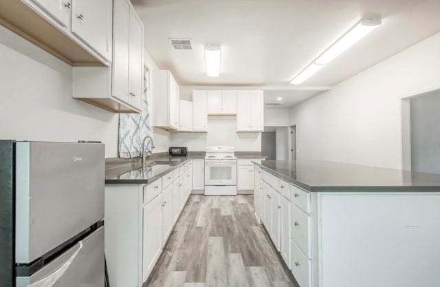 12647 E Clarkson Ave, Kingsburg, CA 93631 - kitchen with sink, white cabinetry, light hardwood / wood-style flooring, stainless steel fridge, and white range with electric cooktop