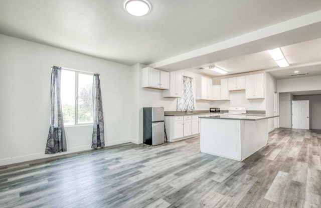12647 E Clarkson Ave, Kingsburg, CA 93631 - kitchen featuring stainless steel fridge, light hardwood / wood-style flooring, and white cabinets