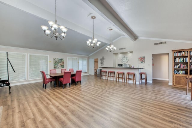 dining space with lofted ceiling with beams, a notable chandelier, and hardwood / wood-style floors