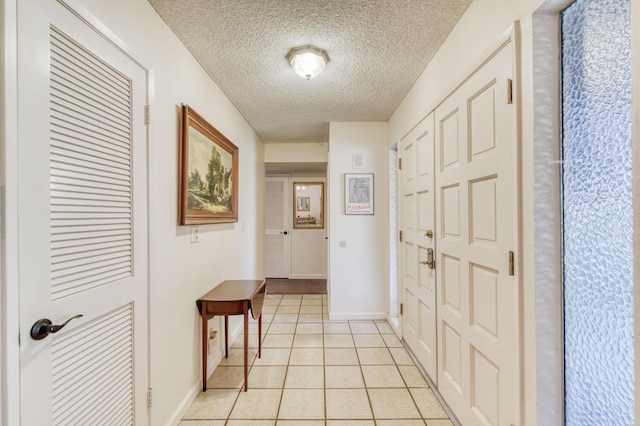 foyer with a textured ceiling and light tile patterned floors