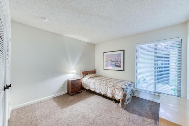 bedroom with light carpet and a textured ceiling