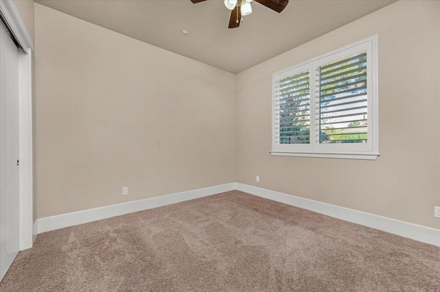 carpeted spare room with ceiling fan